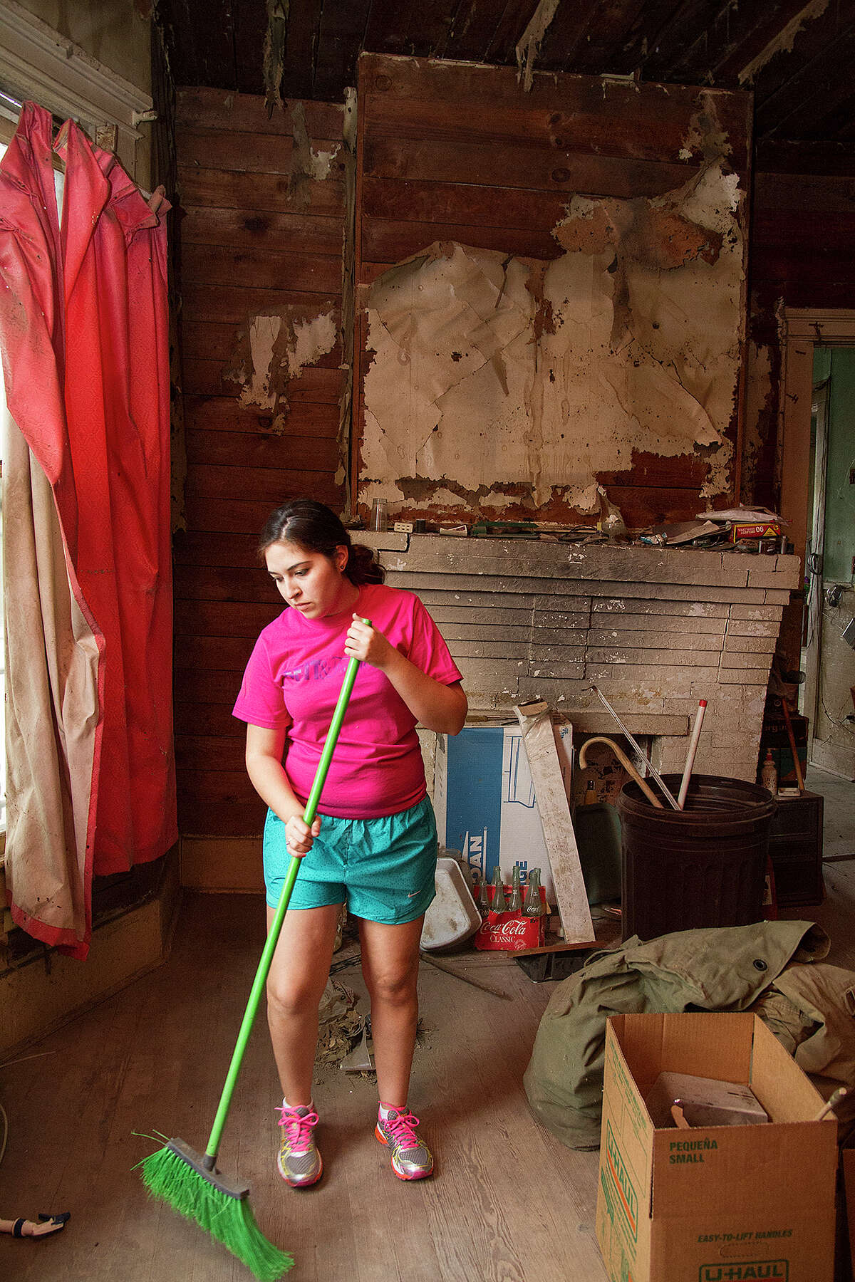 Megan Lenz helps clean up Miguel Calzada's home, Saturday, Dec. 13, 2014 so they can move forward with renovations.