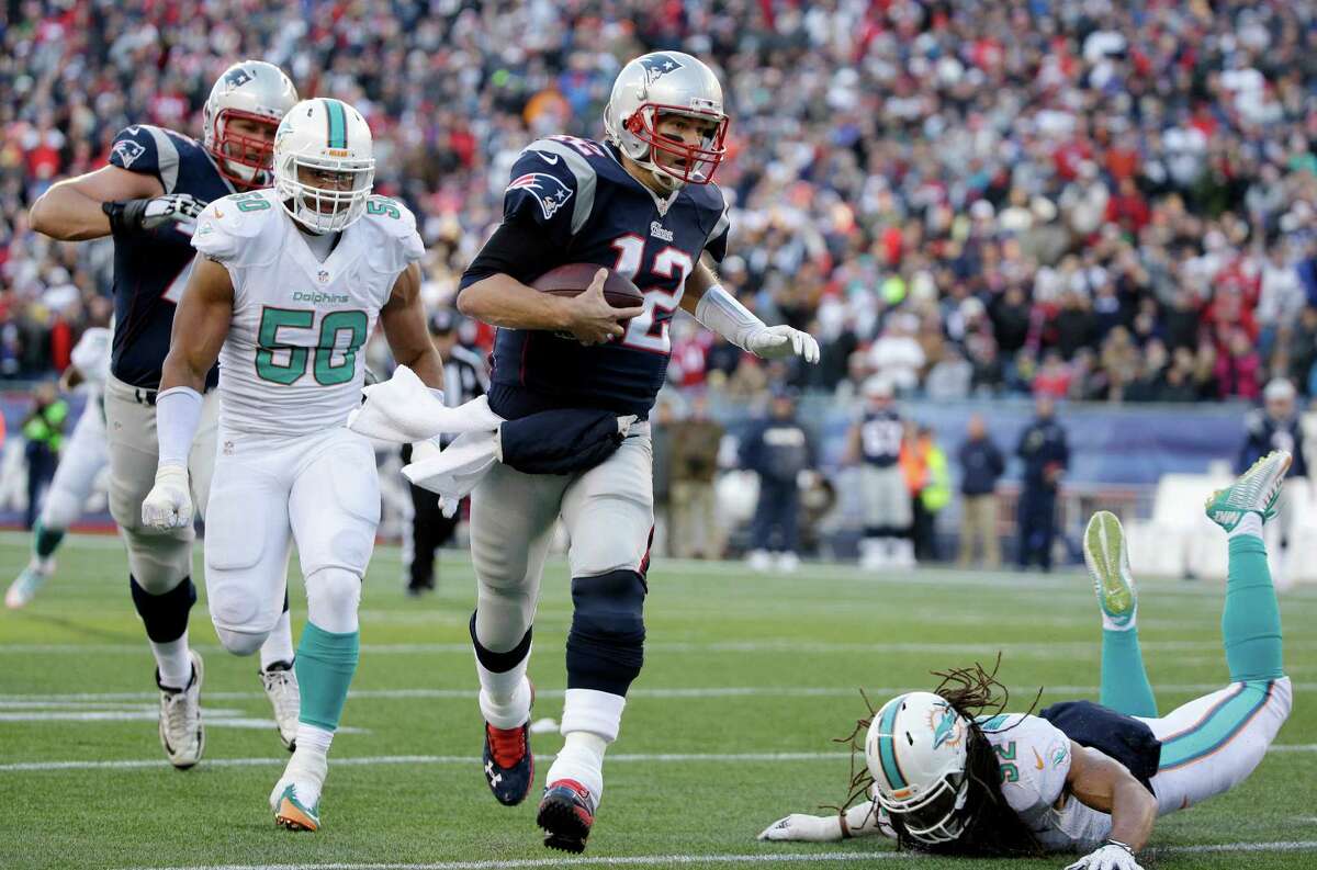 New England Patriots quarterback Tom Brady (12) runs with the ball as Miami Dolphins defensive end Olivier Vernon (50) gives chase in the second half of an NFL football game, Sunday, Dec. 14, 2014, in Foxborough, Mass. (AP Photo/Steven Senne) ORG XMIT: FBO120
