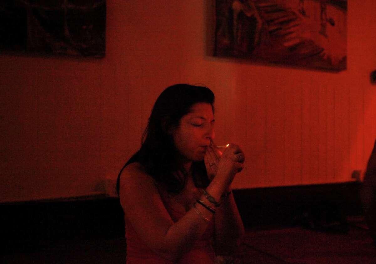 Yanika Schneider lights up during the weekly Ganja Yoga class taught by Dee Dussault at the Merchants of Reality studio in the South of Market neighborhood.