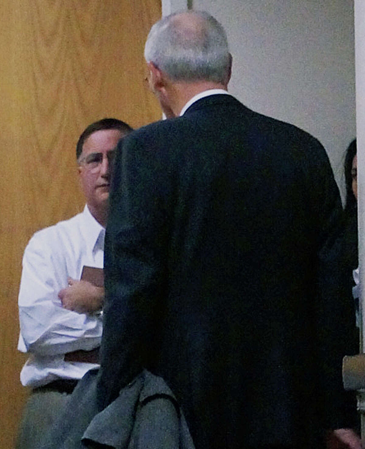 Supt. of Schools David Title, facing camera, huddles in the hallway with attorney Donald Houston after the Representative Town Meeting rejected a proposed contract with 38 school administrators.
