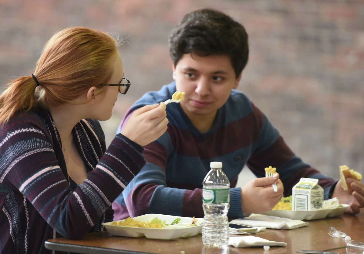 Junior Charlotte Pessall and senior Jace Larriuz eat cafeteria food during their lunch break at Greenwich High School in Greenwich, Conn. Tuesday, Dec. 16, 2014. Earlier this year, the Board of Education opted the high school out of the National School Lunch Program because it wanted to preserve its current menu, as opposed to going along with new restrictions. The goal now is to increase revenue by making the cafeteria's offerings more attractive to students.