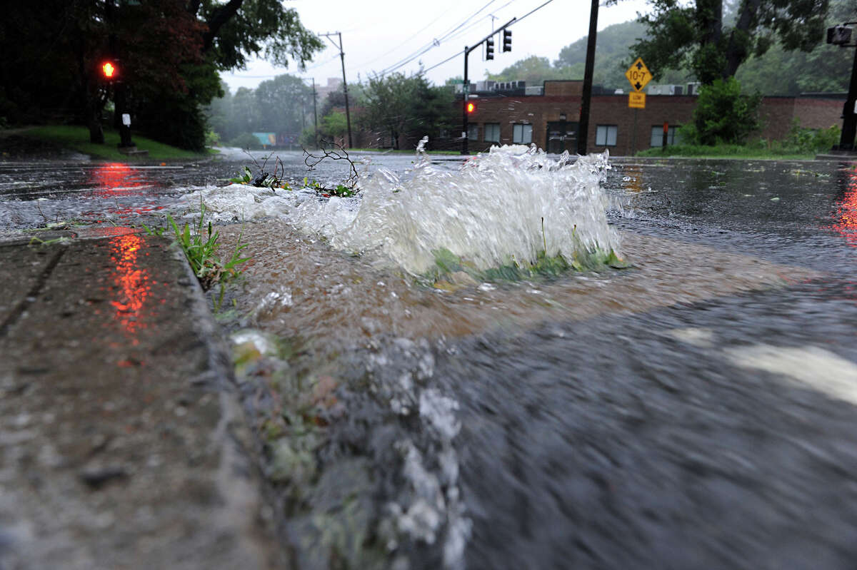 A drain pipe is unable to keep up with the steady flow of rain water flooding Lake Avenue in this file photo.