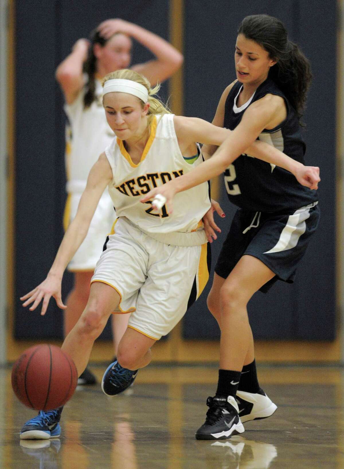 Weston's Taylor Kennedy (21) tries to dribble around Immaculate's Stephanie Bischop (2) during the SWC girls high school basketball game between Immaculate and Weston high schools, on Tuesday night, December 16, 2014, played at WestonHigh School, Weston, Conn.