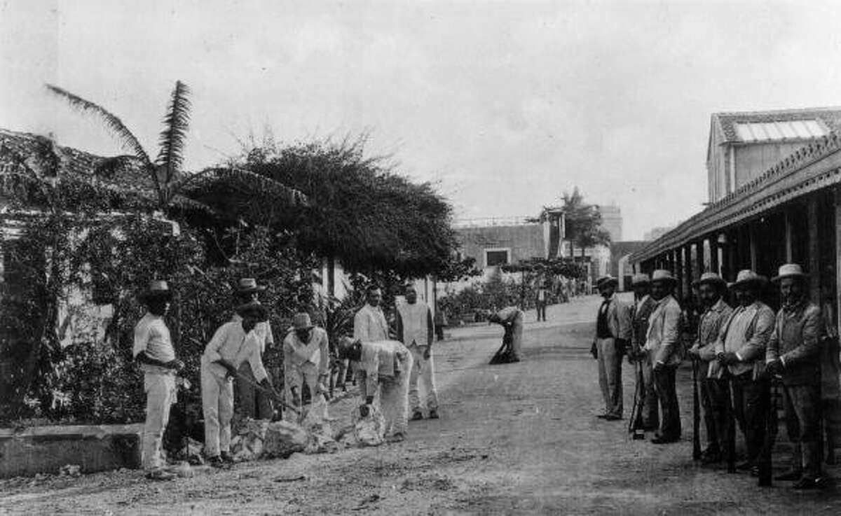 Life in Cuba before the trade embargo A circa-1890 photo of prisoners breaking stones the grounds of Presidio Infirmary under the watchful eye of several armed men in Havana, Cuba.