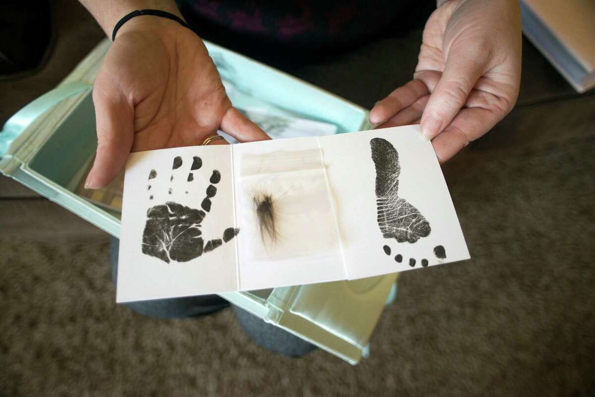 Sitting in her home in Butte, Mont., Jennifer Blaz, 34, holds the small hand print, hair clipping and footprint given to her by the hospital after the death of her daughter, Mattisyn Blaz, in 2013. Matthew Blaz, 33, was sentenced to life in prison without parole for the death of their infant daughter.