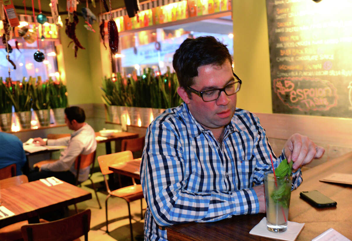 Michael Young, who was trained by prominent Cuban chef Douglas Rodriguez, said he hopes the thawing of US relations with Cuba will lead to a cultural exchange. Young owner of the Mexican restaurant Bodega Taco Bar, comments on the news about Cuba while he sits at the bar with a mojito at the restaurant in Fairfield, Conn., on Wednesday Dec. 17, 2014.