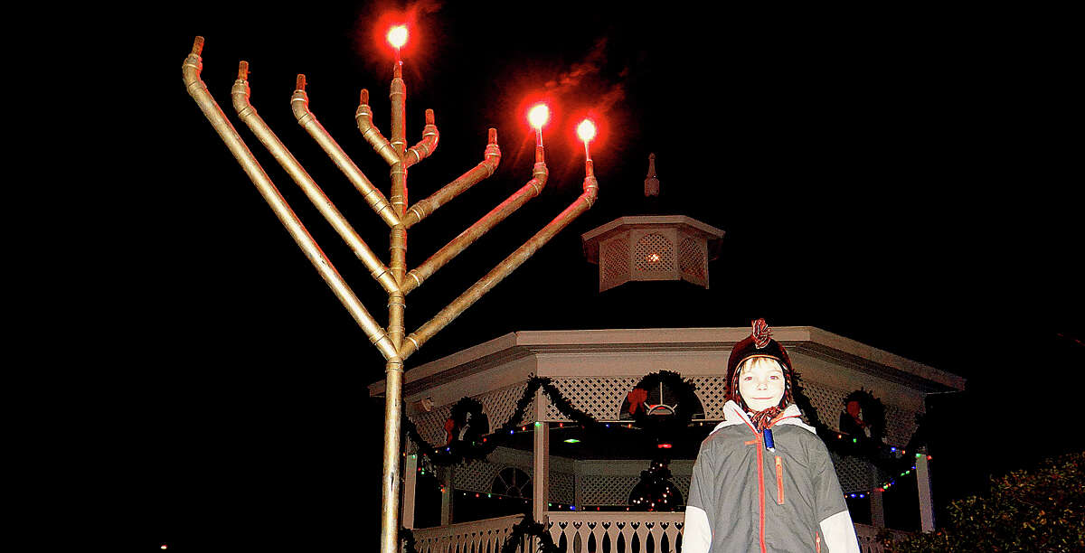 Aiden Anderson, 6, of Fairfield, next to a menorah on Sherman Green, where a lighting ceremony Wednesday celebrated Hanukkah, the Festival of Lights.
