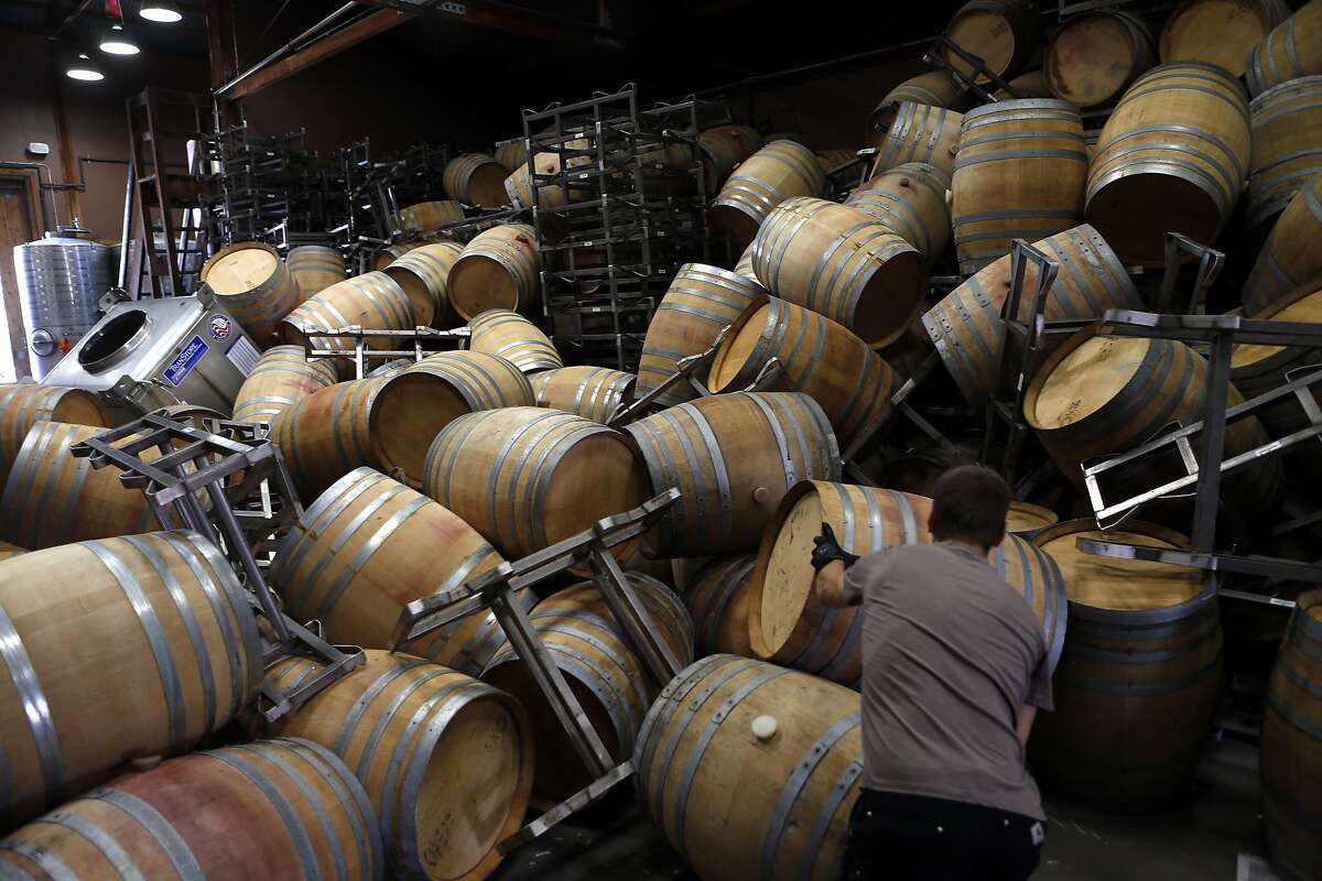 Saintsbury Winery's Ry Richards works on removing the stacks of empty barrels that tumbled over after an earthquake in Napa, Calif. on Sunday, August 24, 2014,