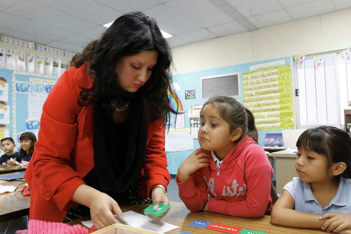 Teacher Letisia Huertado helps first-graders Destiny Valle and Ashley Vargas construct sentencesat Parkview School in El Monte (Los Angeles County).