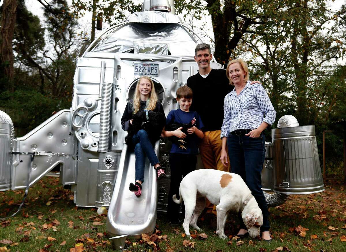 Mary Magsamen and her husband, Stephan Hillerbrand, are pictured with their kids, Madeleine, 11, and Emmett, 8, along with dogs Penny and Annie and Chocolate the chicken, in front of a space craft that was built in the backyard for an art project.