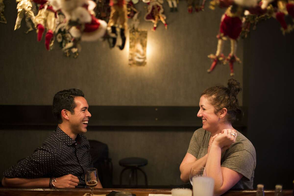 Anthony Lupian, of San Francisco, talks to Ashley Fargeon, of San Francisco, at Brass Tacks, a Hayes Valley bar, in San Francisco, Calif. on Thursday, December 18, 2014. The bar has a vast collection of Santa dolls from the previous tenant, the gay bar Marlena's.