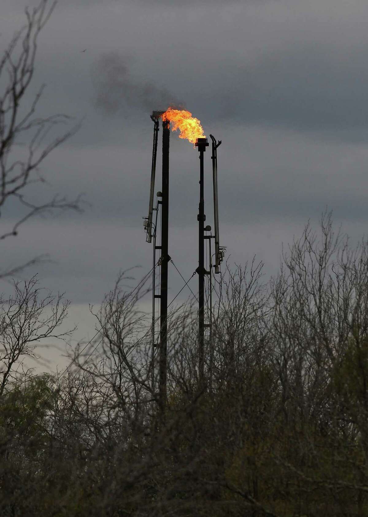 A flare burns natural gas at the Brown Trust oil lease near Cotulla on Highway 97 in La Salle County on Thursday, Dec. 11, 2014. Operated by Carrizo (Eagle Ford) LLC, flares at the lease burned more than 250 million cubic feet of gas in the first seven months of 2014, nearly a third of overall production according to data obtained from the Texas Railroad Commission. (Kin Man Hui/San Antonio Express-News)