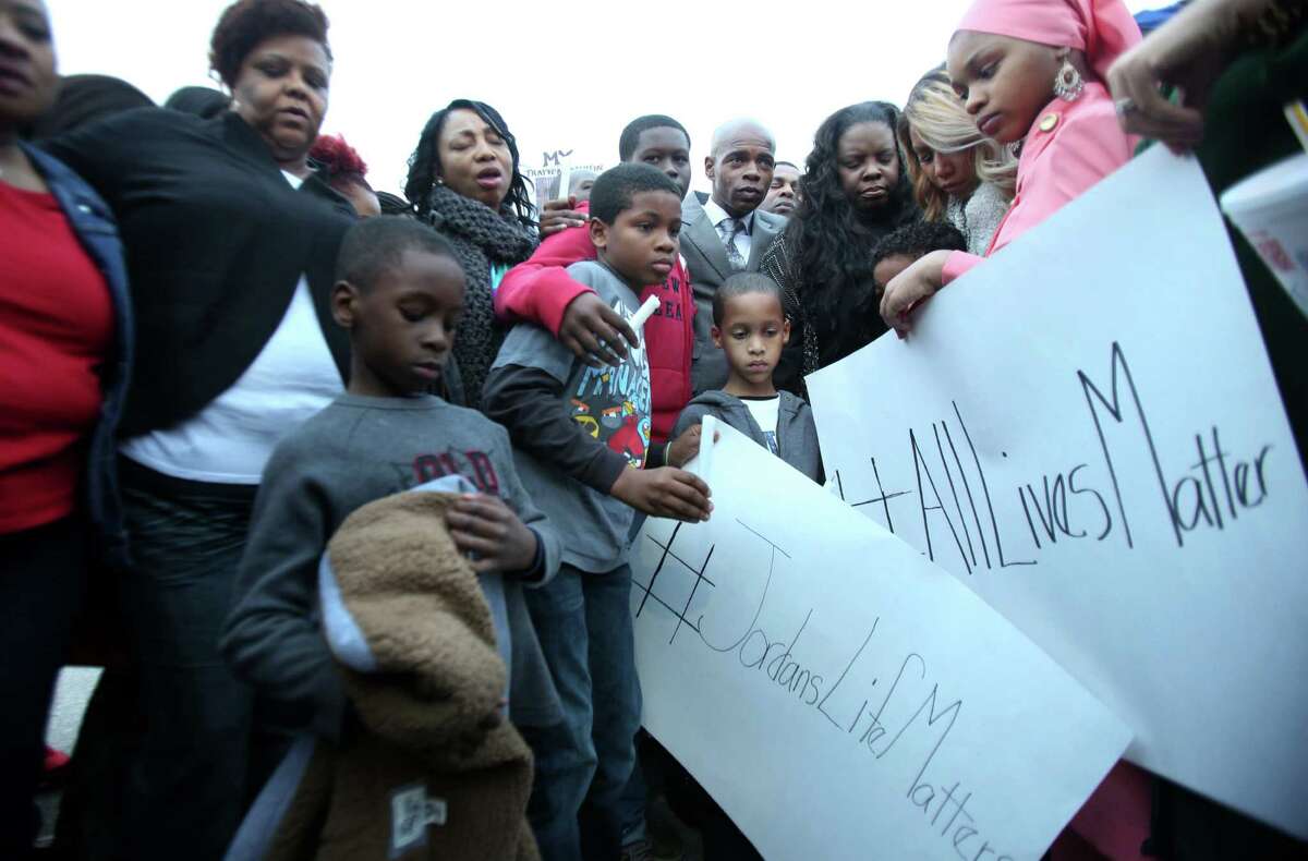 The Baker family and supporters hold a vigil in the parking lot where Jordan Baker was shot by police on Sunday, Dec. 21, 2013, in Houston. ﻿