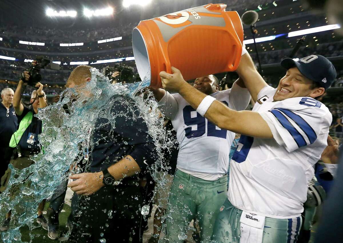 Jason Garrett is doused by Jeremy Mincey and Tony Romo after their 42-7 win over the Indianapolis Colts.