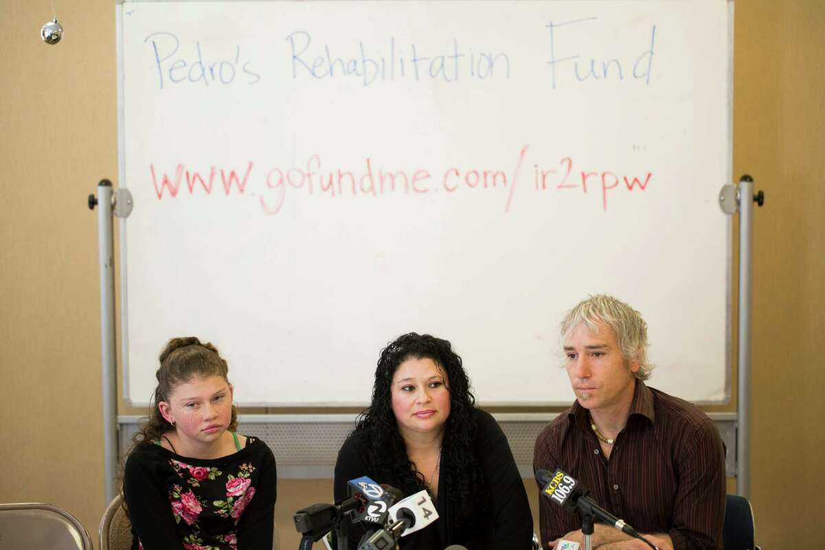 Maricela Perez, center, wife of Pedro Perez, a San Leandro man who fell from an 11-story building in San Francisco while window washing, speaks about her husband's recovery with her daughter Gaby Perez, 11, left, and Colin O'Leary, right, a Service Employees International Union organizer, at the SEIU United Service Workers West office in Oakland, Calif. on Monday, December 22, 2014.