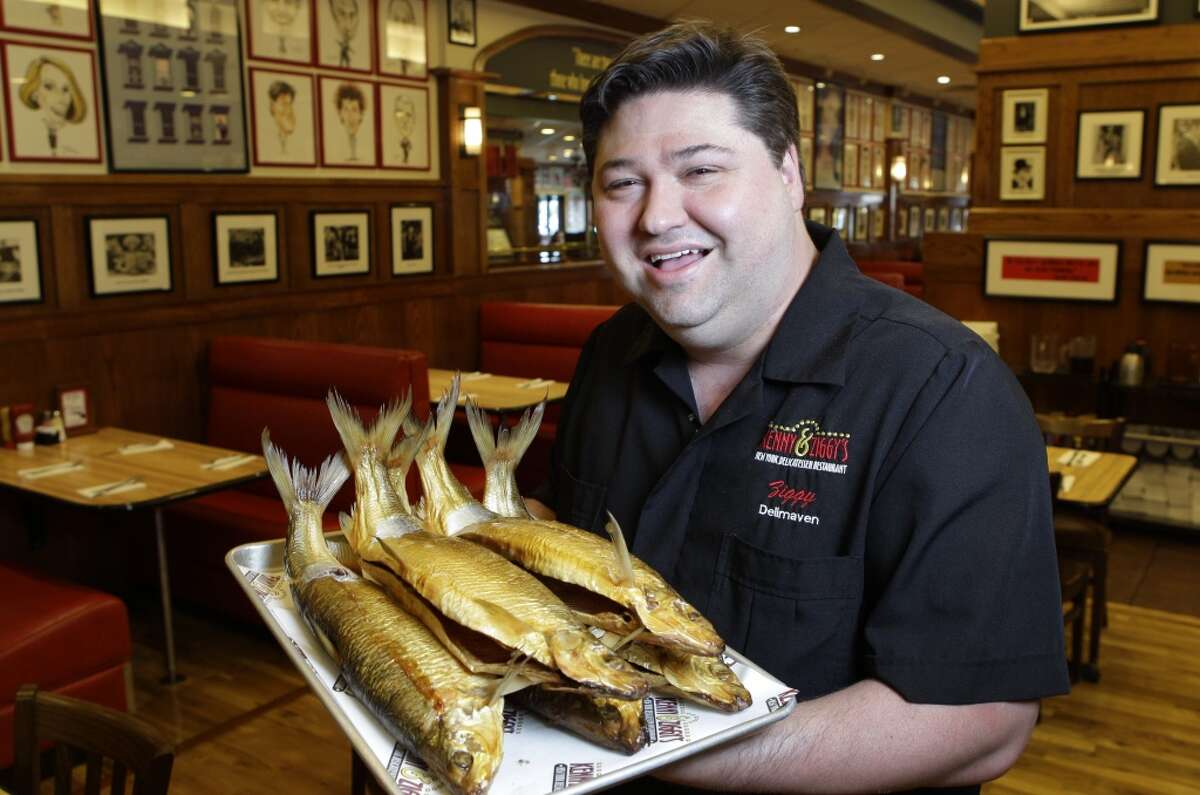 Ziggy Gruber, owner of Kenny and Ziggy's, poses with a tray of white fish.