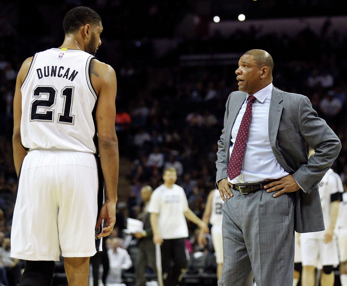 San Antonio Spurs' Tim Duncan talks with Los Angeles Clippers head coach Doc Rivers during a timeout in second half action Monday Dec. 22, 2014 at the AT&T Center. The Spurs won 125-118.