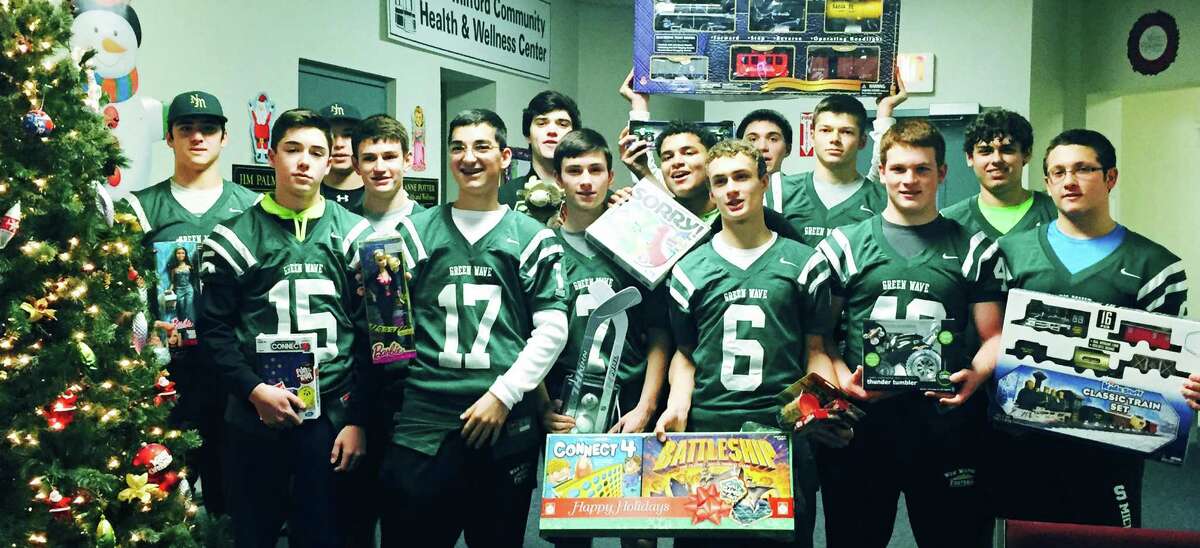 Lending their efforts to the New Milford High football team's toy drive are, from left to right, front row, Mike Heymach, Liam Kenny, Guy Scarcella, Dan Krepil, Andre Taylor, Griffin Mercier, John Phillips and Trevor Hynda, and, back row, Chris Ryan, Alex Lubas, Matt Ryan, Pat Ryan, Robert Cicero and Mike D'Ambrosio. The Green Wave athletes are shown delivering toys they had collected to the Social Services office at the Richmond Citizen Center. December 2014 Courtesy of Beverly Ryan