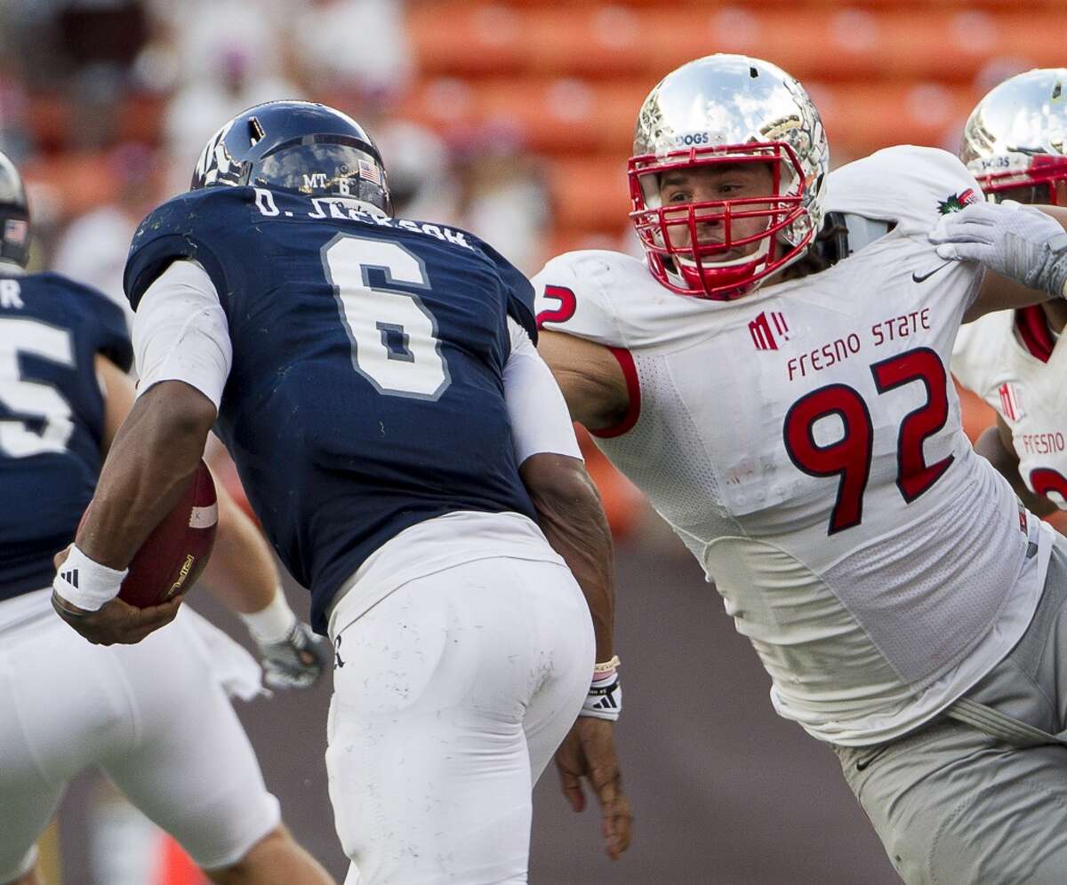Fresno State defensive lineman Tyeler Davison (92) attempts to grab and tackle Rice quarterback Driphus Jackson (6) in the second quarter of the Hawaii Bowl NCAA college football game, Wednesday, Dec. 24, 2014, in Honolulu. (AP Photo/Eugene Tanner)