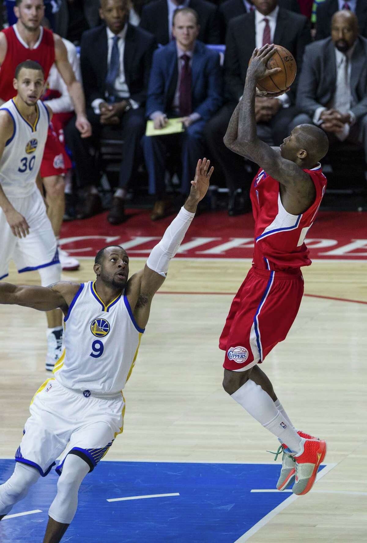 Jamal Crawford (right) shoots over Andre Iguodala in the first half, when the Warriors led for all but 18 seconds. Los Angeles shot poorly but kept it close.