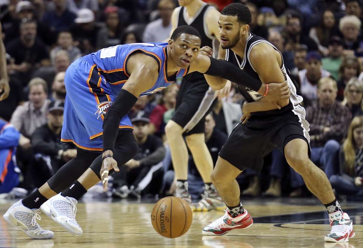 Oklahoma City Thunder's Russell Westbrook grabs for a loose ball against San Antonio Spurs' Cory Joseph during first half action Thursday Dec. 25, 2014 at the AT&T Center.