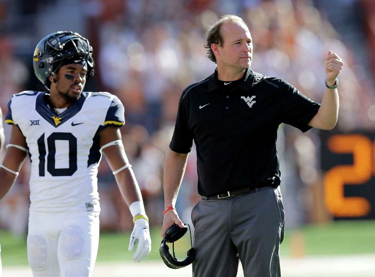 West Virginia coach Dana Holgorsen motions toward one of his players during a timeout in the first half against Texas on Nov. 8, 2014, in Austin.