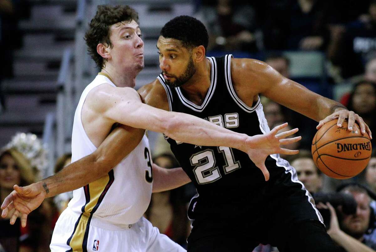 San Antonio Spurs forward Tim Duncan (21) drives against New Orleans Pelicans center Omer Asik during the first half of an NBA basketball game, Friday, Dec. 26, 2014, in New Orleans.