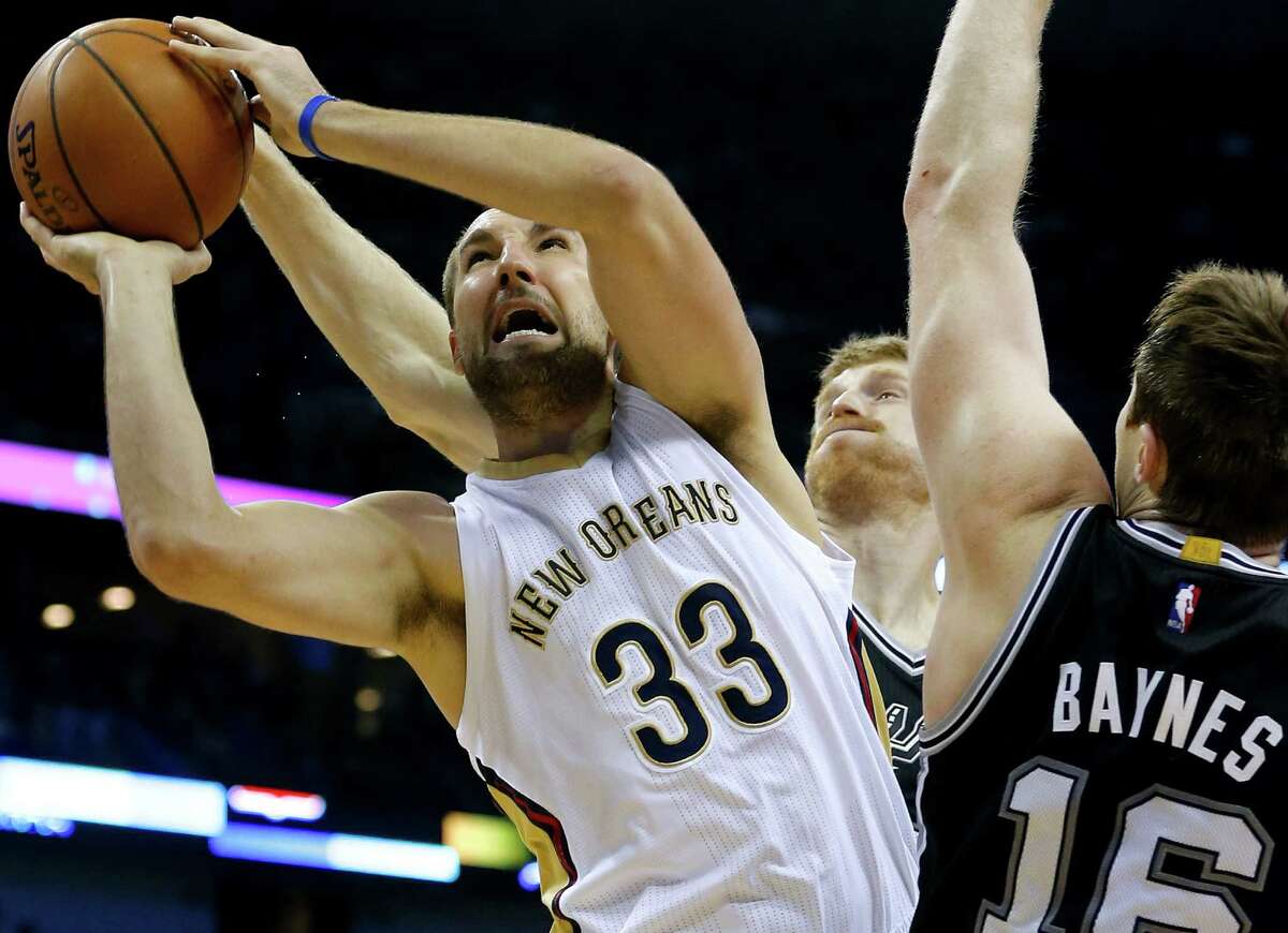 New Orleans Pelicans forward Ryan Anderson (33) shoots against San Antonio Spurs forwards Matt Bonner, back, and Aron Baynes, right, during the first half of an NBA basketball game, Friday, Dec. 26, 2014, in New Orleans. The Pelicans won 97-90.