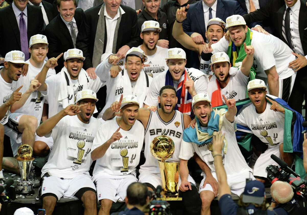 The San Antonio Spurs as they celebrate with the Larry O’Brien NBA championship trophy after the Spurs defeated the Miami Heat 107-84 in Game 5 of the NBA Finals June 14, 2014. Front row from left: MVP Kawhi Leonard, Tony Parker, Tim Duncan, Manu Ginobili and Patty Mills.