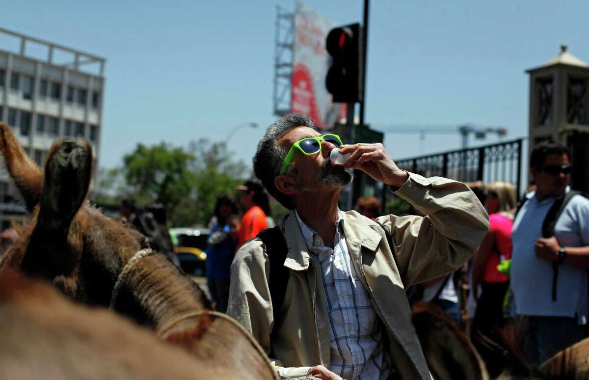 A man stops to drink fresh donkey milk in the street in Santiago, Chile. The use of donkeyís milk has persisted in some parts of the world. Even Pope Francis has said he drank it as a boy in Argentina.