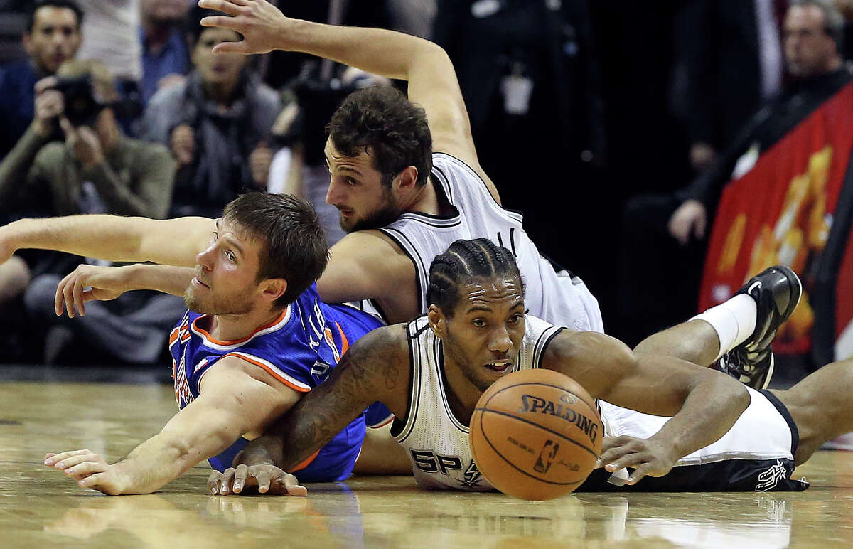 Kawhi Leonard and Marco Belinelli combine to get the ball away from Beno Udrih during a scramble on the floor in the fourth quarter as the Spurs host the New York Knicks at the AT&T Center on January 2, 2014.