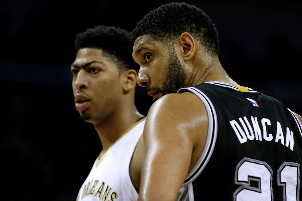 New Orleans Pelicans forward Anthony Davis (23) and San Antonio Spurs forward Tim Duncan (21) react during the first half of an NBA basketball game, Friday, Dec. 26, 2014, in New Orleans.