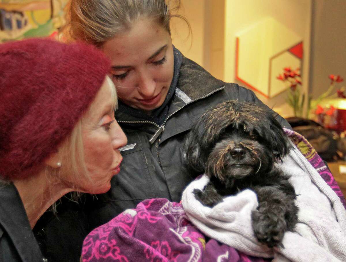 ﻿Simone Westra, left, and owner Eva Routs fawn over rescued dog Onyx, who had been trapped under a neighbor's foundation for two nights.