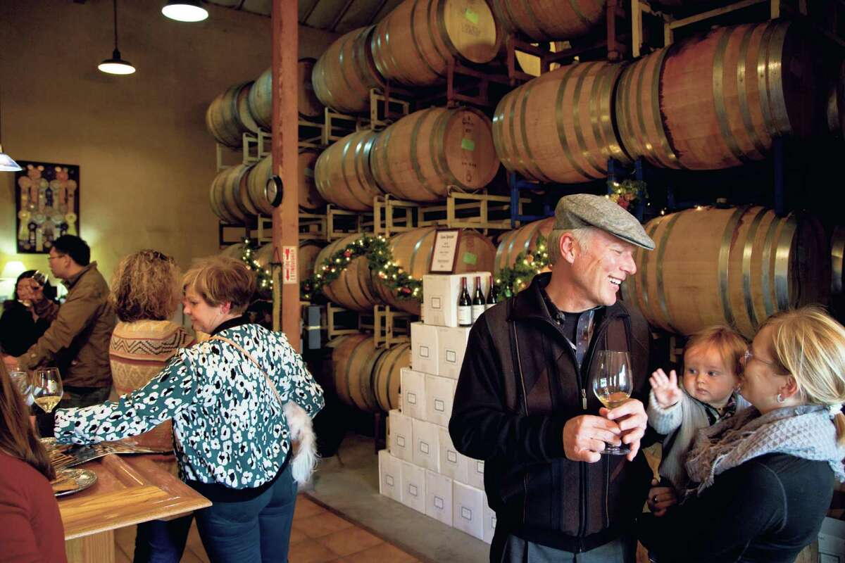 Steve Marshall talks to Morgen Marshall and her son Xander in the tasting room and barrel room at Claiborne & Churchill Vintners in San Luis Obispo., California December 20, 2014.