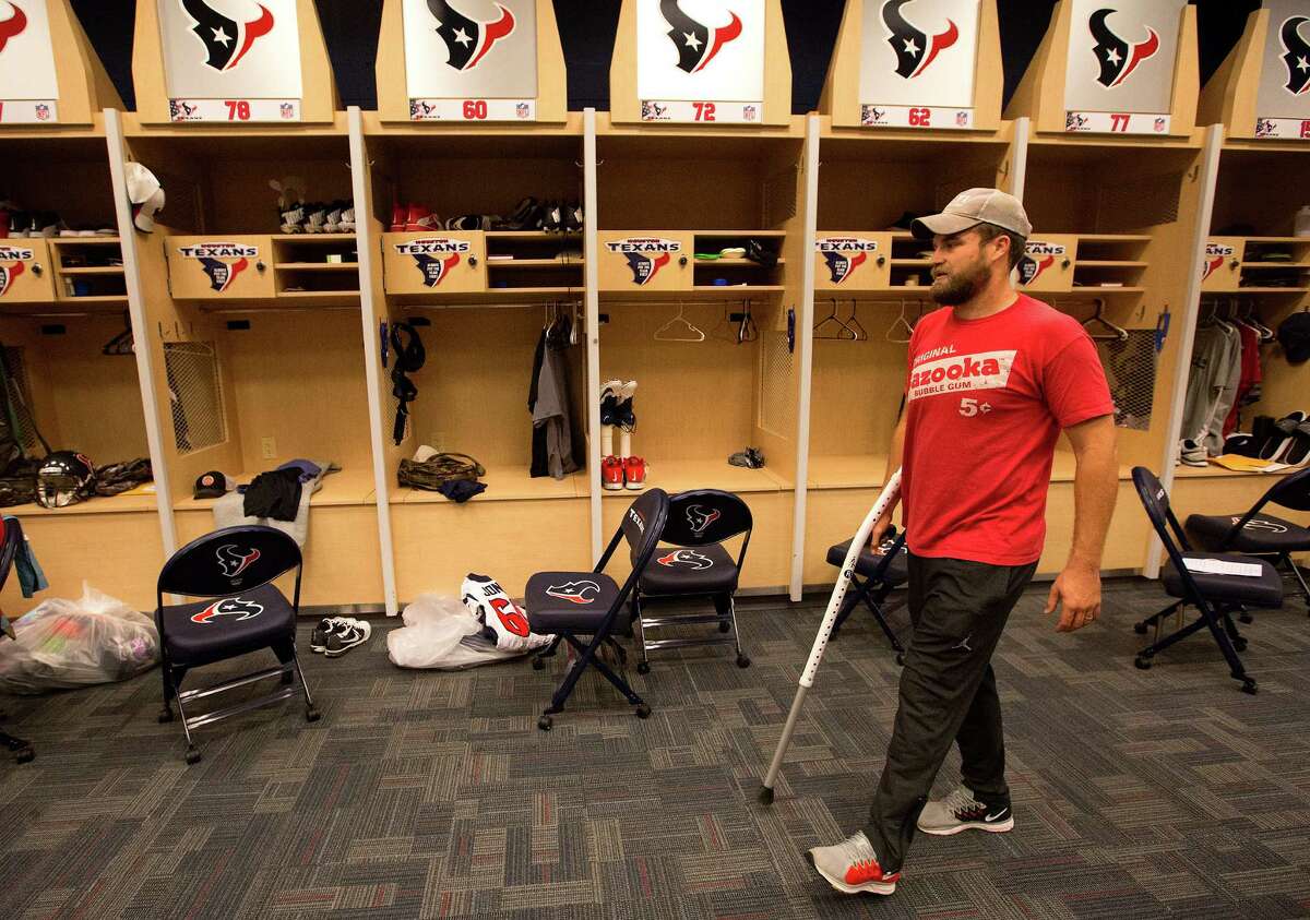 Hobbled quarterback Ryan Fitzpatrick walks through the locker room the day after the season ended with the Texans finishing with a rush to go 9-7.