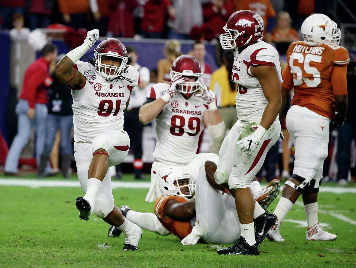 Darius Philon (91) and Mitchell Loewen (89) of the Arkansas Razorbacks celebrate after sacking Tyrone Swoopes of the Texas Longhorns in the first half of the Texas Bowl at NRG Stadium on Dec. 29, 2014 in Houston.
