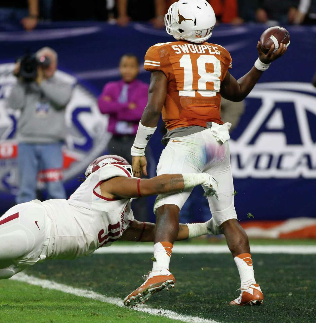 Texas quarterback Tyrone Swoopes tries to get the throw off in the end zone as he is tackled by Arkansas defensive tackle Darius Philon during the third quarter.
