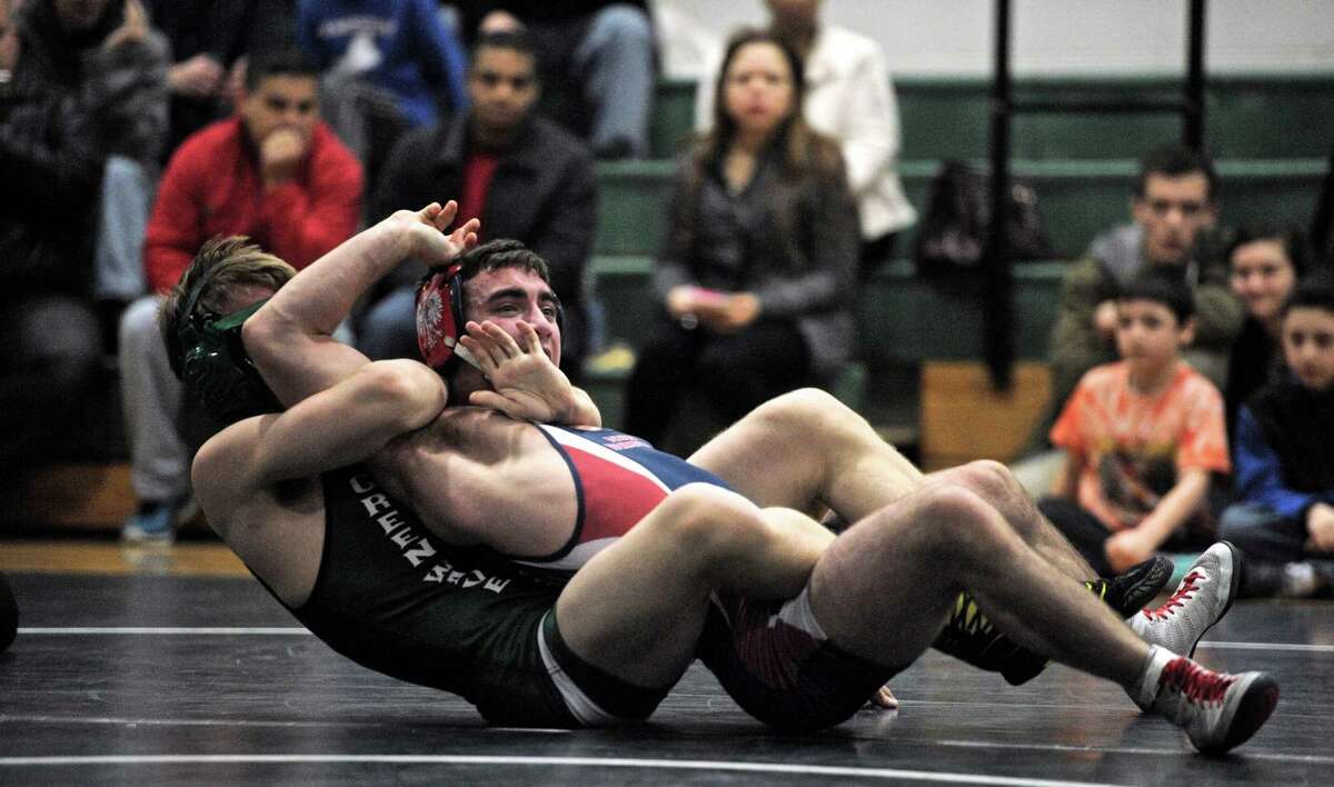 New Fairfield's Tyler Cerlich, top, and New Milford's Zachary Arnold wrestle in the 145 pound weight class during a meet between New Fairfield and New Milford high schools, on Tuesday, December 30, 2014, in New Milford, Conn. New Milford won the meet 60-10.