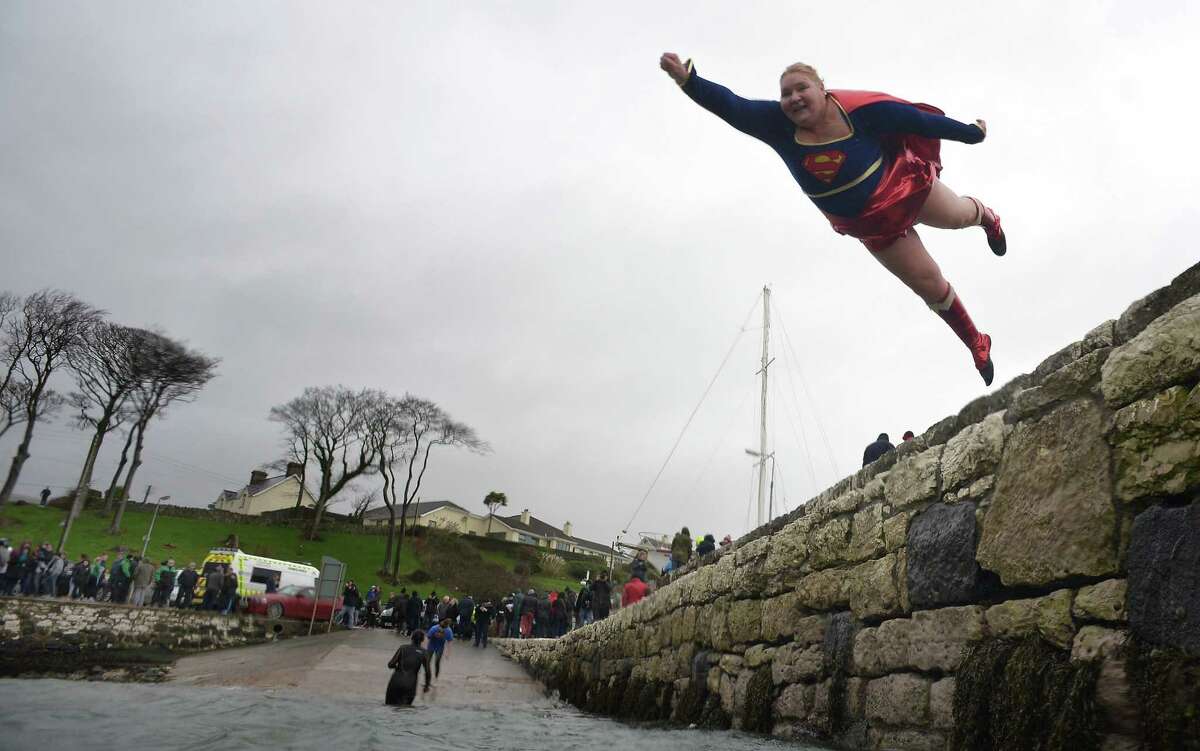 You don't have to be Superman or Superwoman to do this. But it helps. Angela McClements takes the plunge as swimmers brave the icy waters during the New Year's Day swim at Carnlough harbour on Jan. 1, 2015, in Carnlough, Northern Ireland. The annual event on the north Antrim coast upports Spina Bifida and Hydrocephalus charities.