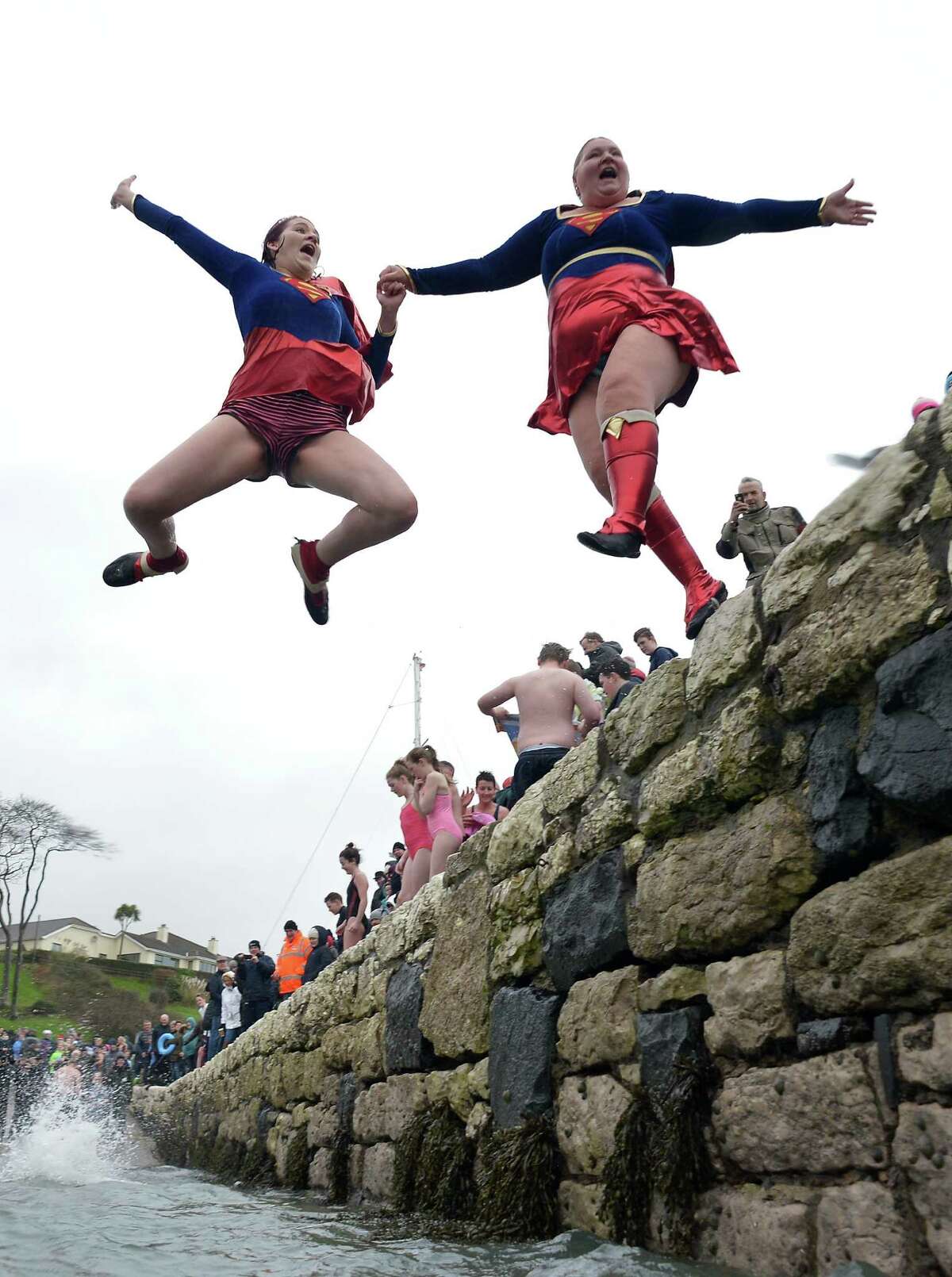  More super heroes take the plunge during the New Year's Day swim at Carnlough harbour in Carnlough, Northern Ireland. 