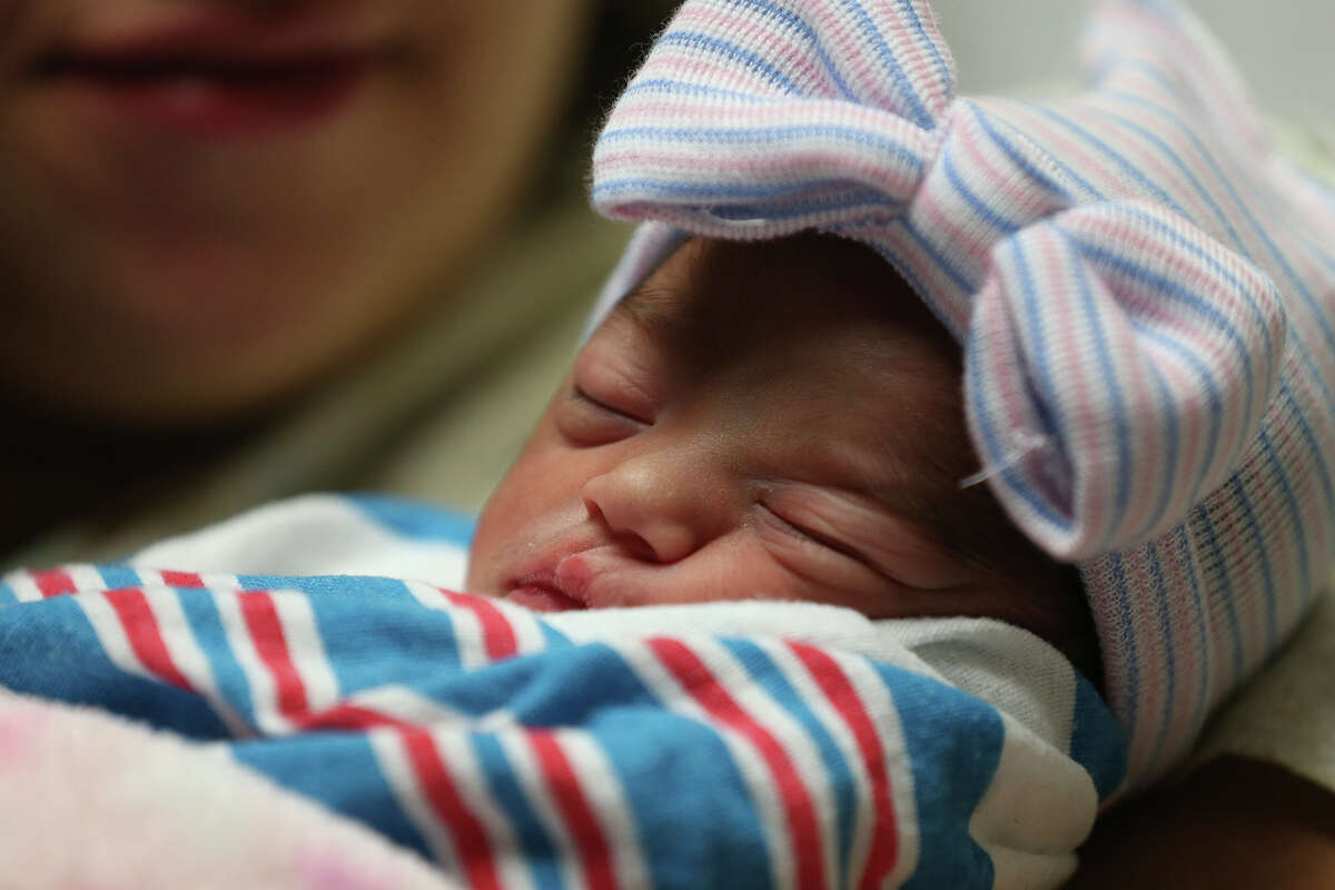 Sarah Allison Gutierrez sleeps in the arms of her mother, Melody Esparza, at Methodist Hospital, Thursday, Jan. 1, 2015. Sarah Allison was the first baby born in the new year in the San Antonio area. She was born at 12:02 a.m. The baby received various gifts from area hospital and a $10,000 scholarship to The Incarnate Word University.