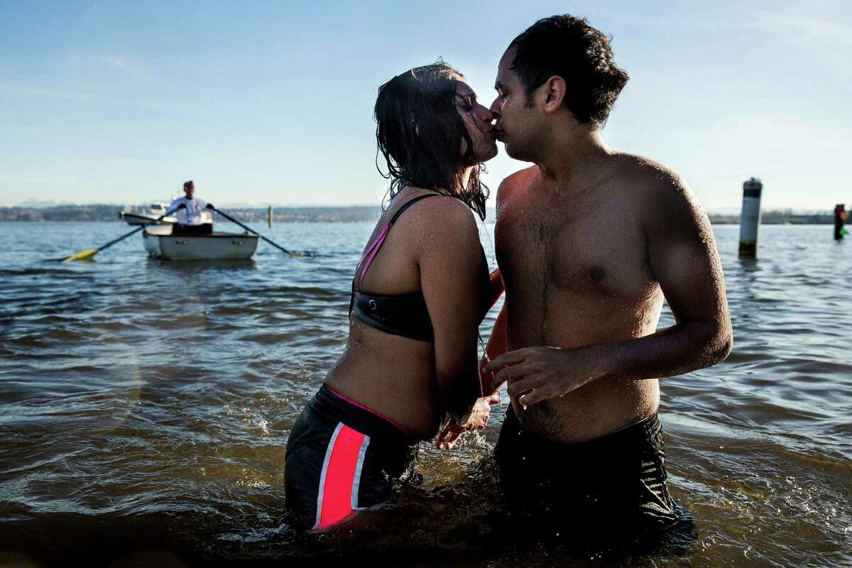 A couple share a kiss in the frigid waters of Pontiac Bay during the 13th Annual Polar Bear Plunge Thursday at Matthews Beach Park.