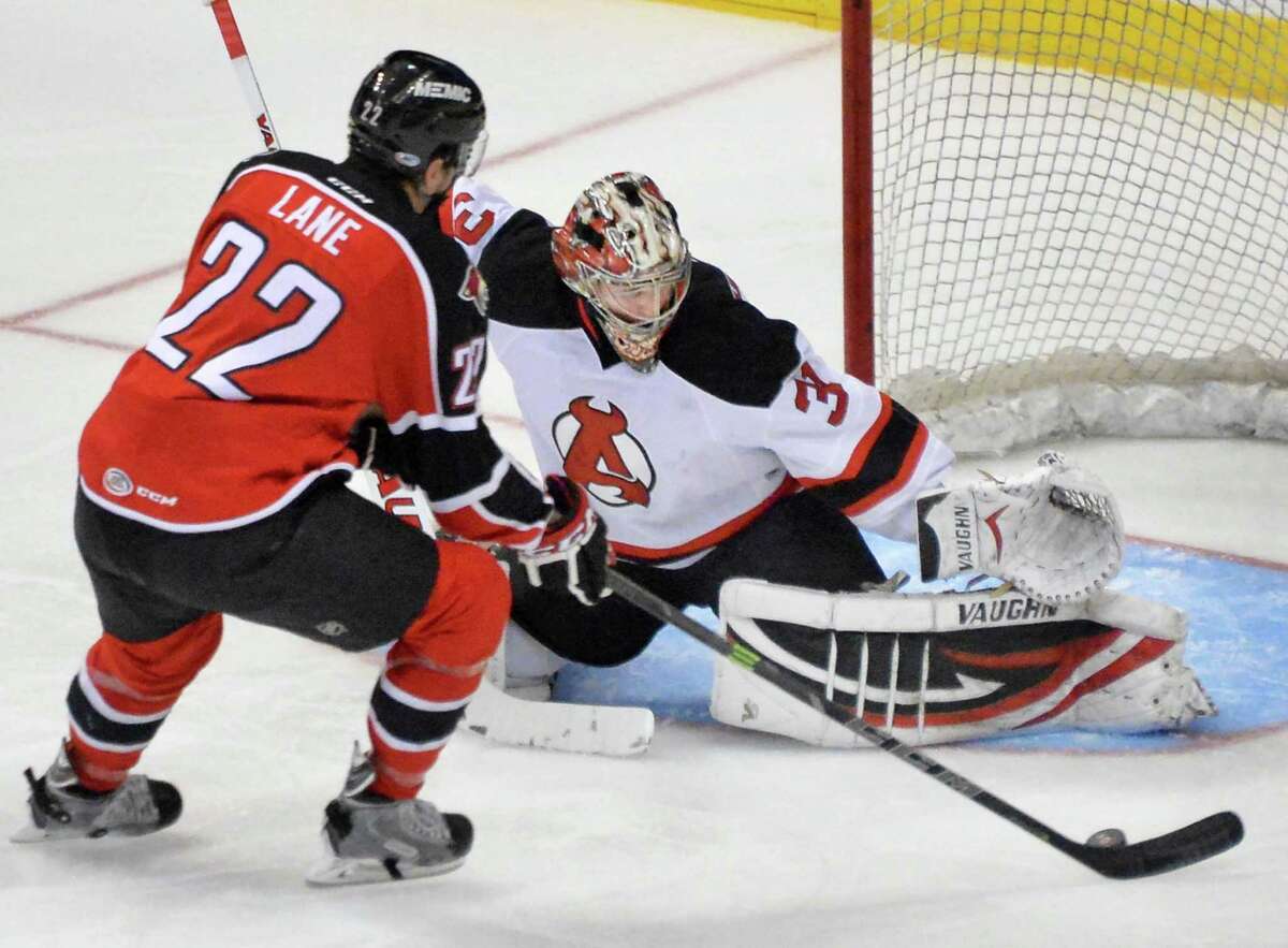 Albany Devils goalie Scott Wedgewood, right, stops a shot on goal by Portland Pirates' #22 Phil Lane during Saturday's game at the Times Union Center Dec. 6, 2014, in Albany, NY. (John Carl D'Annibale / Times Union)