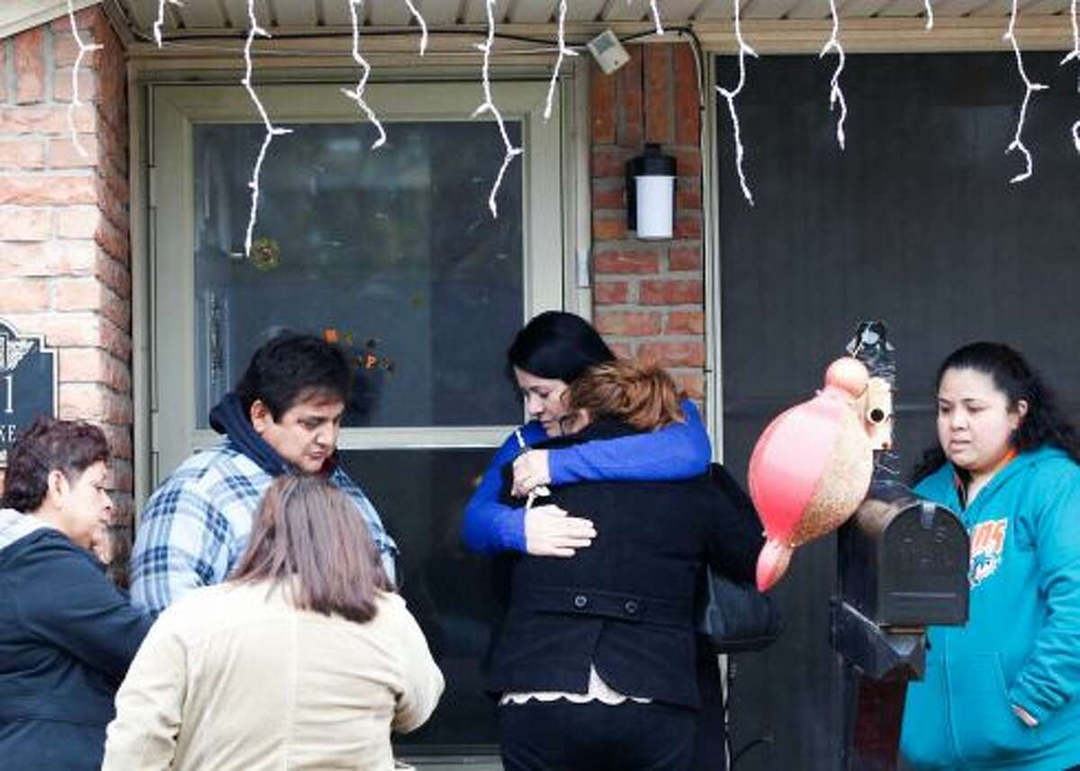 Un amigo de la familia abraza a la hija de Javier Suárez Rivera, Keyla, de 16 años, mientras familiares y amigos lamentan la muerte del hombre debido a una bala perdida en las primeras horas de 2015.