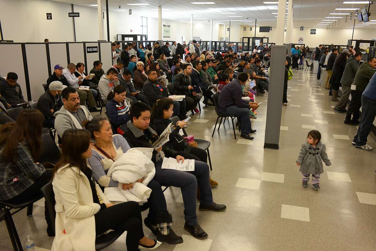 Scores of people wait for their turn at the DMV on Friday, January 2, 2014 in San Jose, Calif. The DMV is allowing undocumented immigrants to obtain driver's licenses under AB 60.