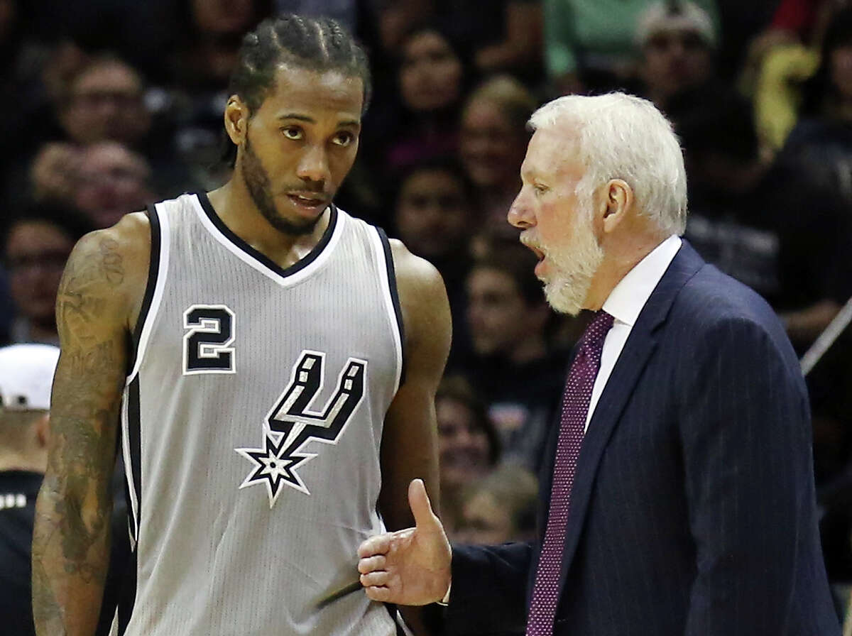San Antonio Spurs' Kawhi Leonard talks with head coach Gregg Popovich during a timeout in second half action against the Brooklyn Nets Saturday Nov. 22, 2014 at the AT&T Center. The Spurs won 99-87.