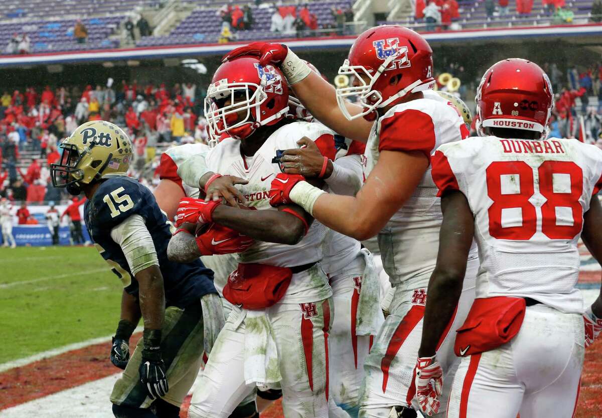 Pittsburgh defensive back Reggie Mitchell (15) walks away as Houston wide receiver Deontay Greenberry celebrates with offensive lineman Alex Cooper, second from right, and wide receiver Steven Dunbar (88) after catching a game-winning 2-point conversion during the second half of the Armed Forces Bowl NCAA college football game, Friday, Jan. 2, 2015, in Fort Worth. Texas. Houston won 35-34. (AP Photo/Sharon Ellman)