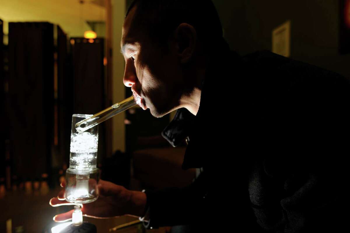 VapeXhale CEO Seibo Shen smokes medical marijuana out of a vaporizer the at Igzactly 420 cannabis club in San Francisco.