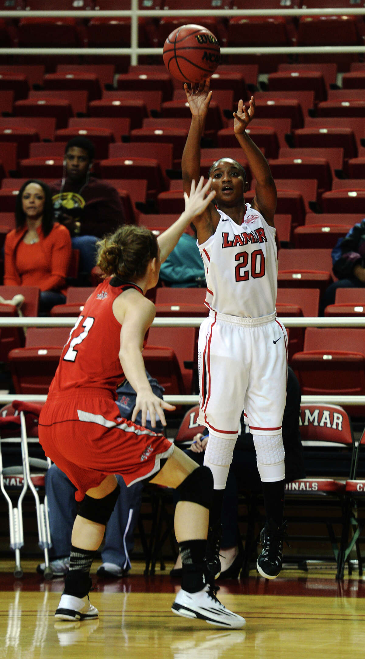 Lamar's JaMeisha Edwards, No. 20, shoots over the head of Nicholls' Jenny Nash, No. 12, during Saturday's game. The Lamar Lady Cardinals hosted the Nicholls Colonels at the Montagne Center on Saturday. Photo taken Saturday 1/3/15 Jake Daniels/The Enterprise