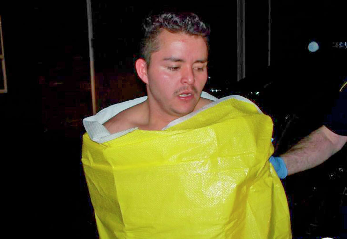 In this photo released by the Keizer, Ore., Police Department, 24-year-old Guillermo Brambila Lopez, of Woodburn, Ore., is wrapped in a blanket following his arrest, Sunday, Jan. 4, 2015. Police said Lopez broke into two homes in Keizer, drinking alcohol and using the hot tub at one of them.